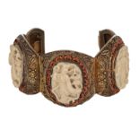 An Oriental filigree gilt silver bracelet set with basso-relievo cut ivory plaques surrounded by cor