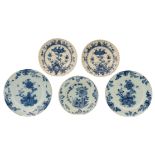 A lot of five blue and white floral decorated Dutch Delftware plates, two of them with a fluted rim,