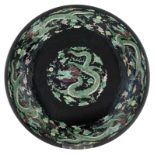 A Chinese black ground and famille verte dish, both sides decorated with dragons, chasing the flamin
