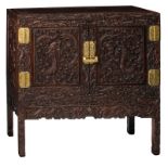 An imposing rosewood two-doors chest, decorated with richly bas-relief sculpted dragons and brass mo