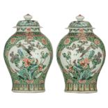 A pair of Chinese floral decorated famille verte vases and covers, the roundels with birds on flower