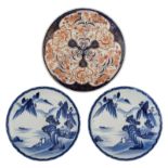 Two Japanese blue and white plates, decorated with a mountainous river landscape; added a ditto Imar