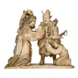 A Japanese ivory okimono depicting a goddess offering a present to a warrior, with black stained eng