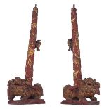 A pair of Chinese gilt and red dragon relief decorated wooden candlesticks, the bases Fu lion-shaped