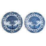 A pair of large blue and white decorated Dutch Delftware plates, the centre depicting a tea tree, ma