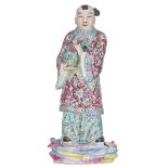 A Chinese famille rose porcelain group, depicting a standing figure, holding a basket with flowers a