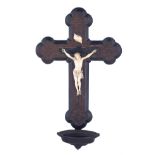 A finely sculpted ivory Corpus Christi on a Gothic Revival dark composite crucifix with a Holy Water