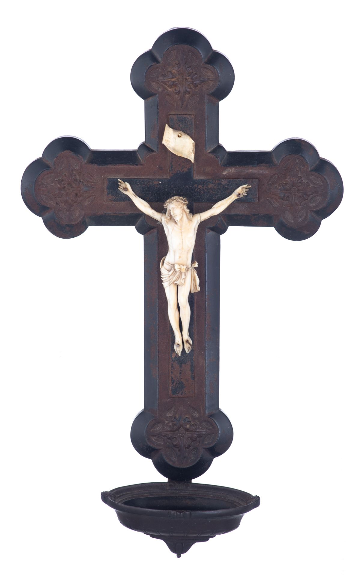 A finely sculpted ivory Corpus Christi on a Gothic Revival dark composite crucifix with a Holy Water