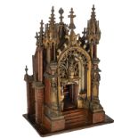 A rare gilt oak Gothic Revival shrine shaped like a miniature cathedral, the central niche encloses