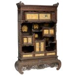 An imposing richly carved mahogany Meiji period Japanese cabinet, decorated with mother-of-pearl and