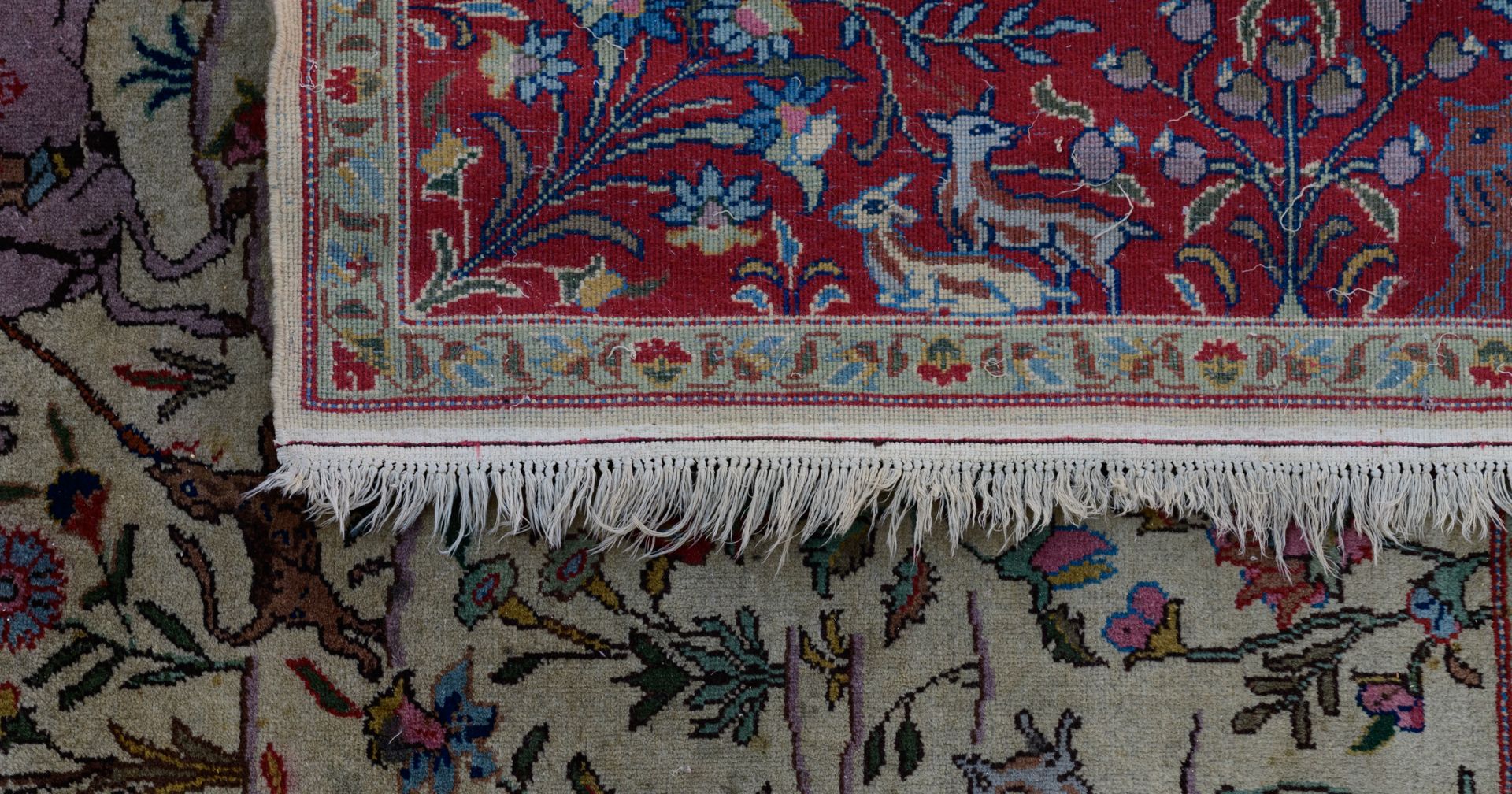 An Oriental woollen rug, decorated with hunting scènes to the center, and with animals and floral mo - Image 4 of 9