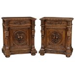 A pair of richly sculpted oak Renaissance style cupboards, the central roundel decorated with an abu