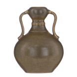 A Chinese teadust-glazed double gourd vase with handles, with a Yongzheng incised mark, on a hardwoo