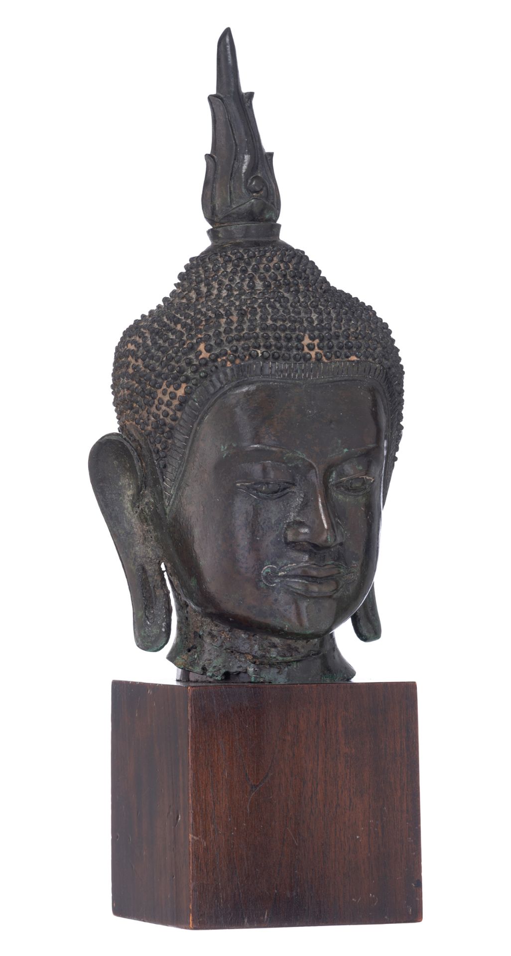 An Oriental bronze group, depicting the head of the Buddha, on a wooden base, H 40,5 cm