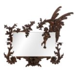 An imposing and richly sculpted walnut wall mirror, decorated with a dragon and a putto surrounded b