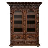 A probably French imposing and abundantly alto relievo carved oak Baroque-inspired bookcase, decorat