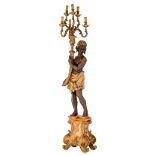 A gilt and patinated blackamoor torchère carrying a six-armed candelabra and standing on a Baroque-i