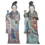 Two exceptional Chinese polychrome decorated figures, depicting a lady, each holding a vase, their r