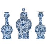 A three-piece blue and white Delftware garniture, horror vacuum decorated with birds in a floral set