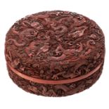 A Chinese style cinnabar red lacquer box and cover, carved with dragons in crashing waves, H 6,5 - ø