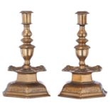 A pair of bronze Baroque candlesticks, with a hexagonal foot decorated with incised grotesques, the