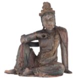 A polychrome painted wooden seated Guanyin in a relaxed posture