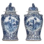 A pair of Chinese floral decorated blue and white vases and covers