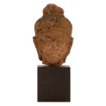 A Thai red sandstone Buddha head with traces of black lacquer
