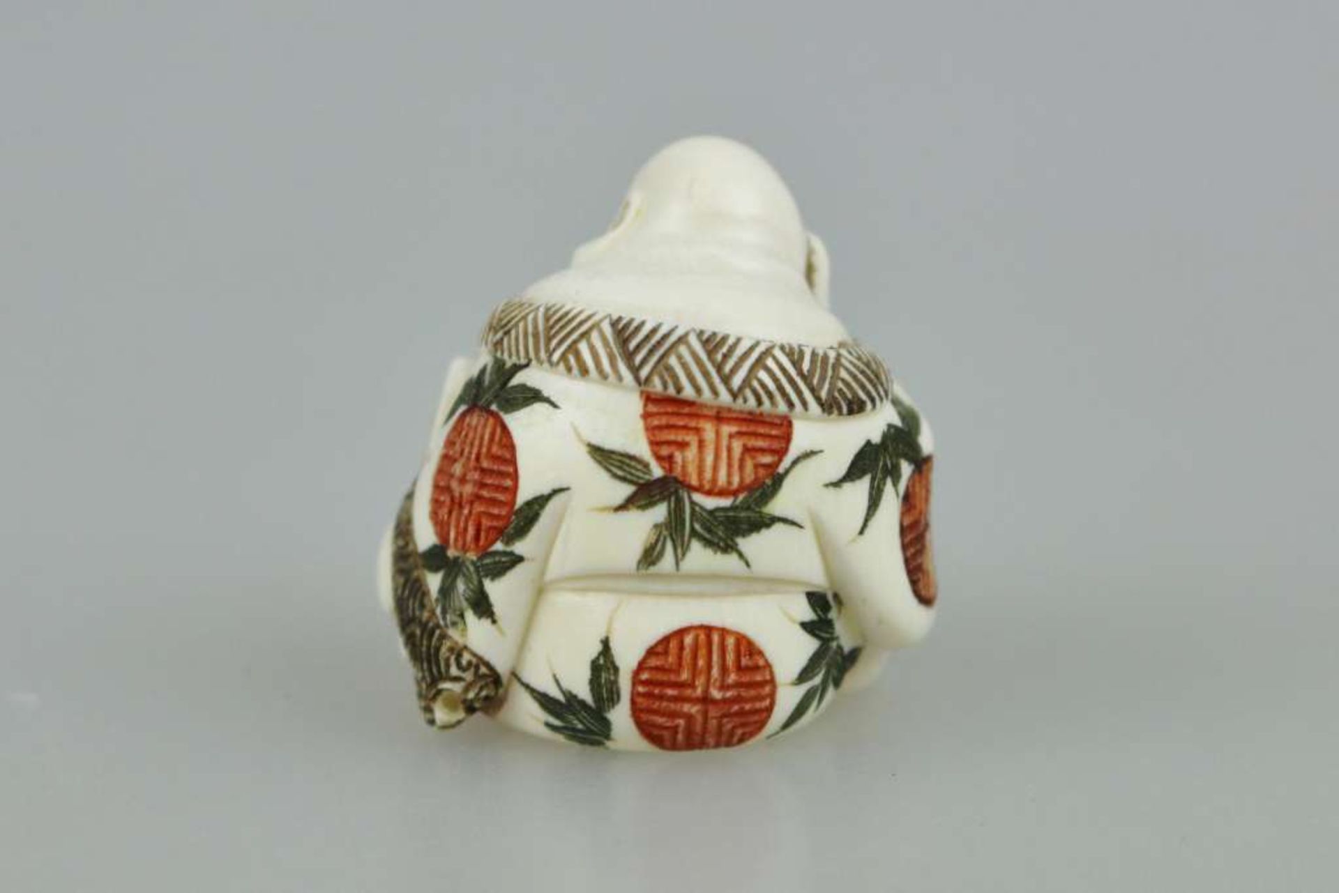 Netsuke, Japan, wohl 19. Jh., Glücksgott Hotei mit partiell farbigem Umhang, Elfenbein, am Boden - Bild 3 aus 4