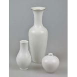 KPM, drei Vasen, 20. Jh.: weiße Halsvase mit Goldrand, Entwurf Johann Henke, H.: 34,5 cm; Kugelvase,