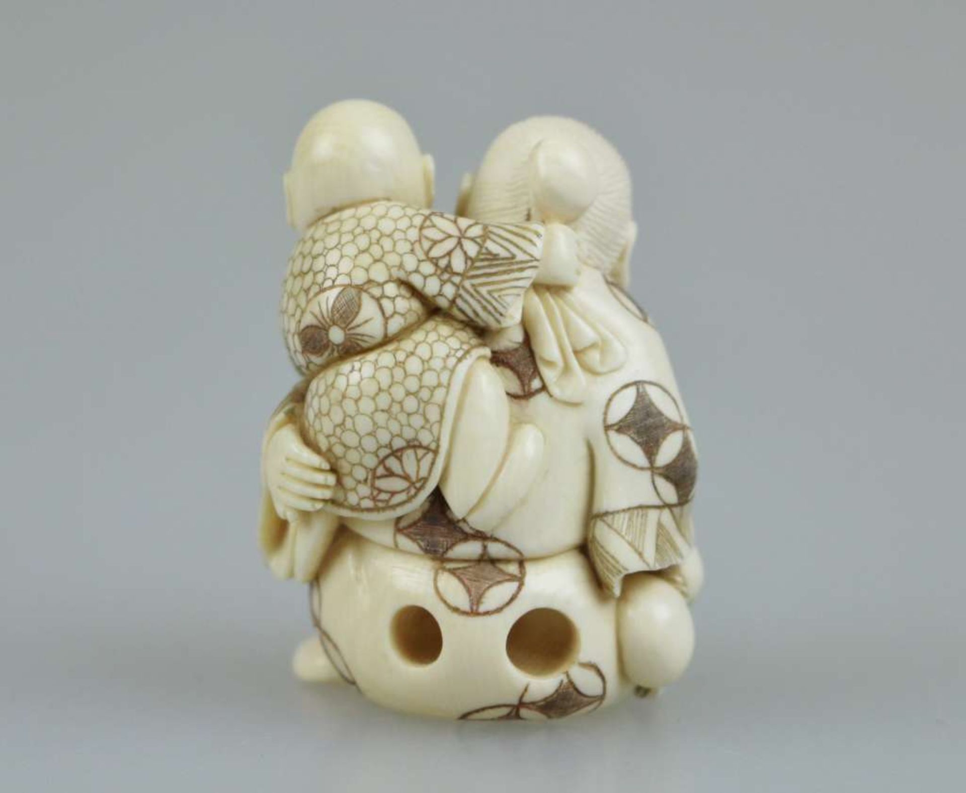 Netsuke, Japan, wohl 19. Jh., sitzender, alter Mann mit Kind auf der Schulter, Elfenbein, am Boden - Bild 3 aus 4