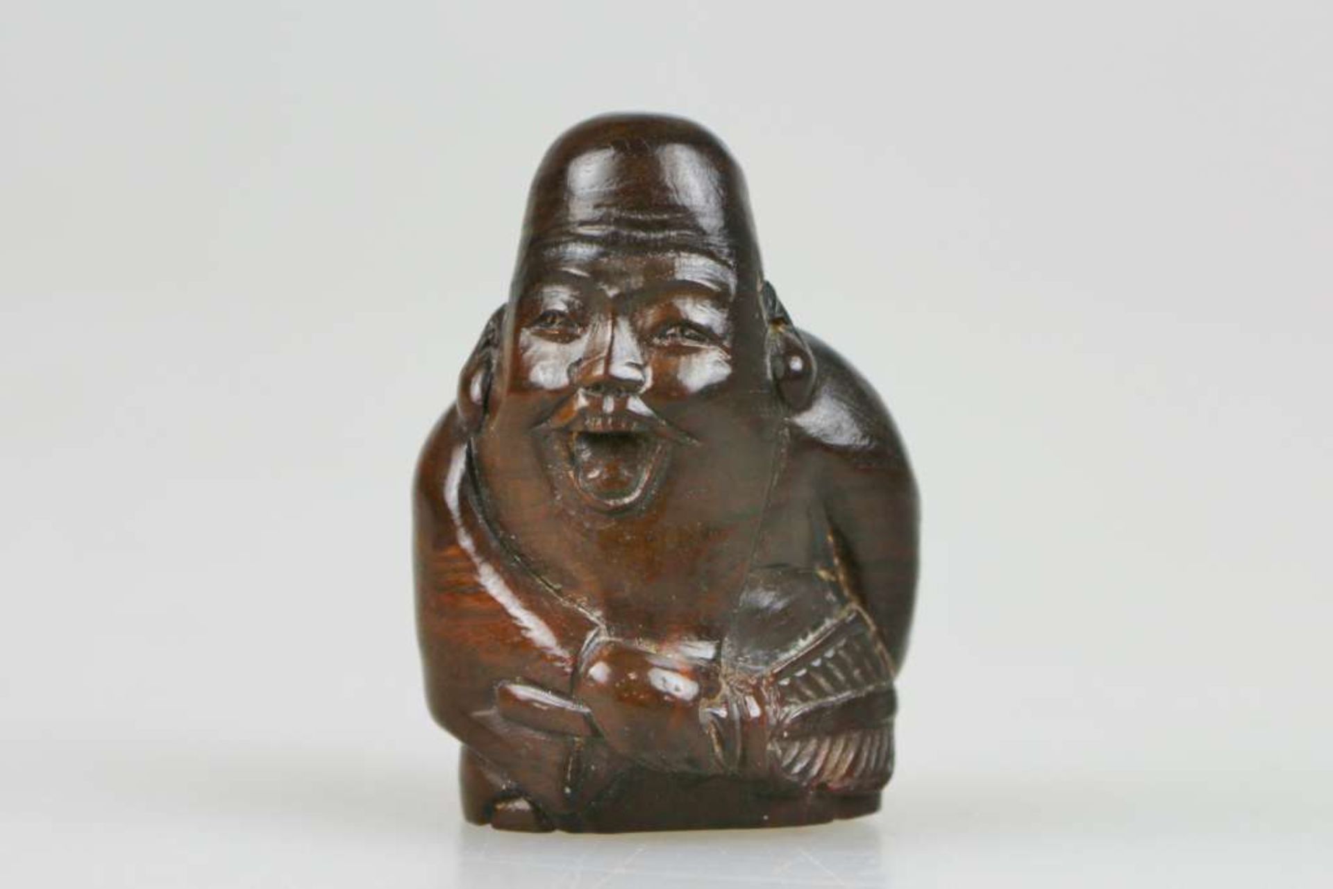 Netsuke, Japan, wohl 19. Jh., Glücksgott Jourojin, Holz, am Boden signiert, H.: ca. 5 cm.