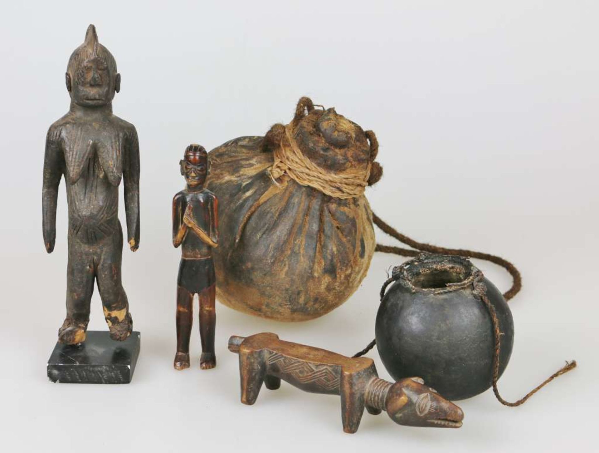Drei Ritualfiguren und zwei Rundbehälter, Afrika, Holz geschnitzt und dunkel patiniert, Kürbis und