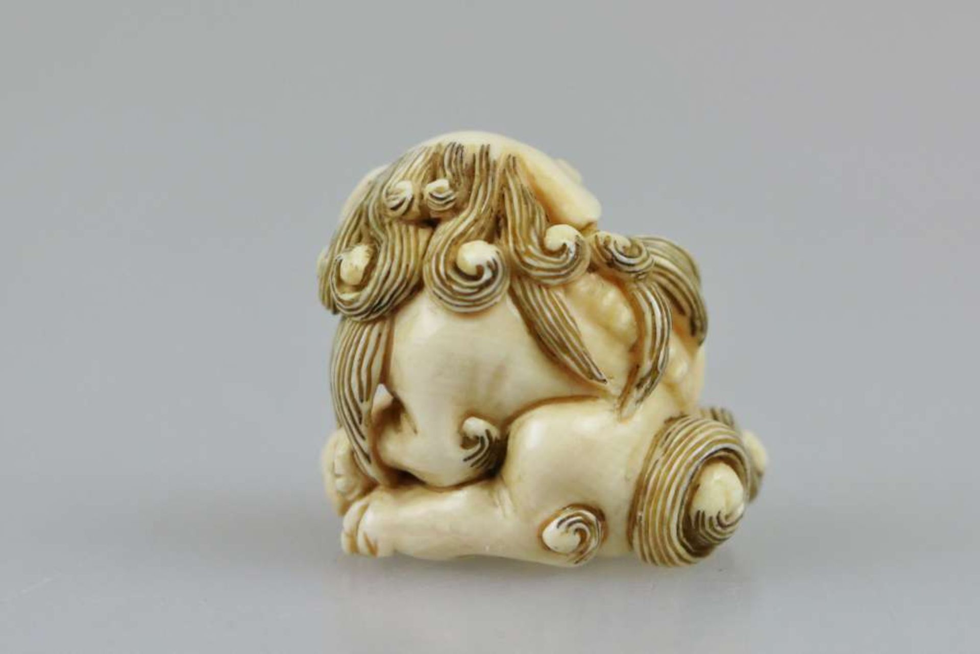 Netsuke, Japan, wohl 19. Jh., Shishi mit Jungem, Elfenbein, am Boden signiert, H.: ca. 3 cm. - Bild 3 aus 4