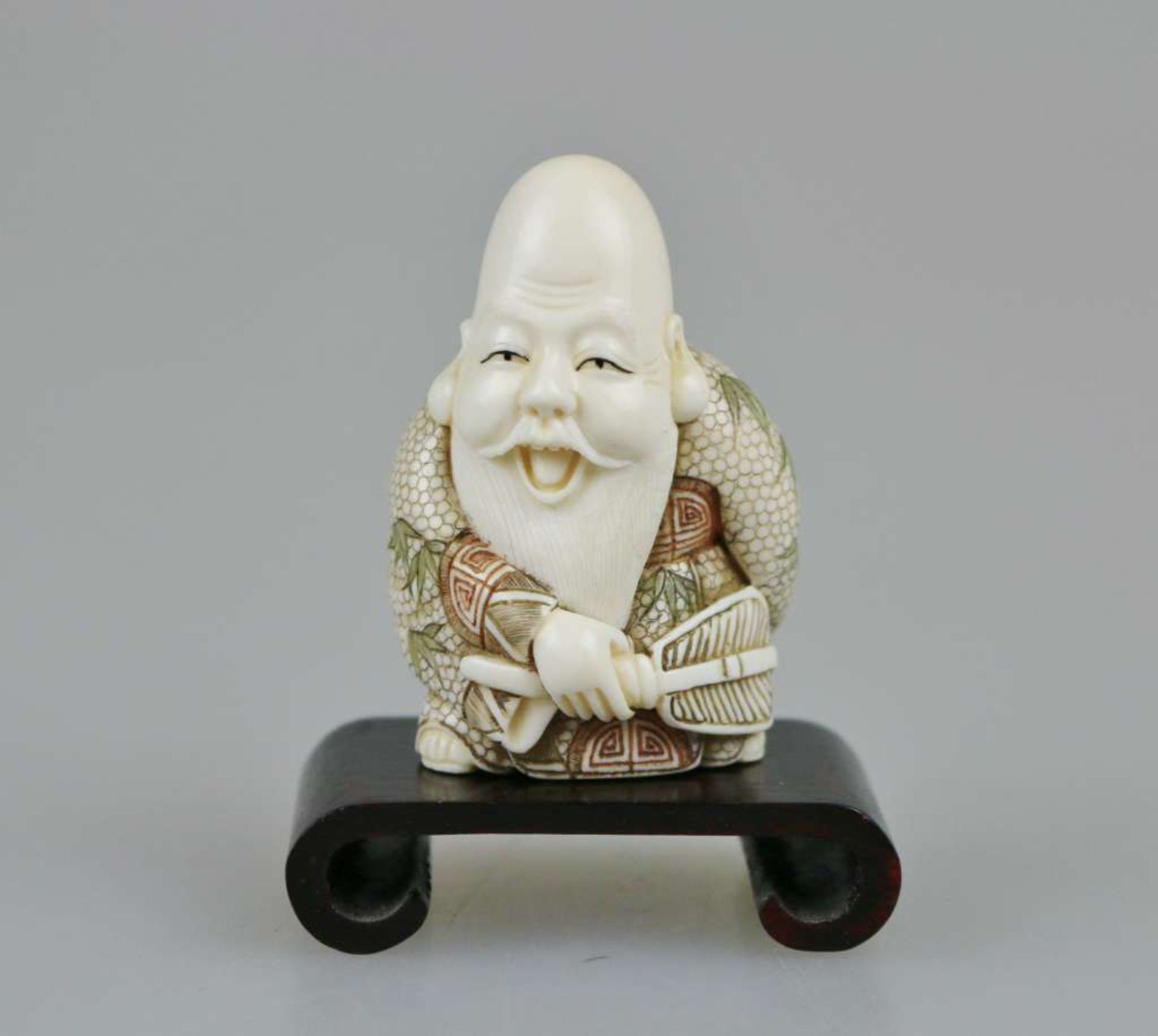 Netsuke, Japan, wohl 19. Jh., Glücksgott Jourojin mit partiell farbigem Umhang, Elfenbein, am