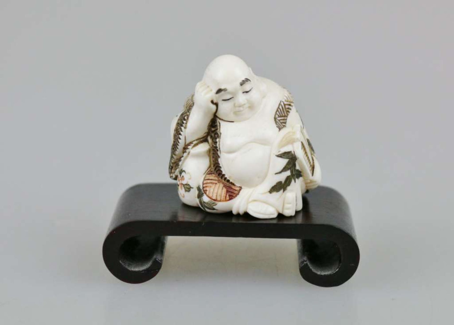 Netsuke, Japan, wohl 19. Jh., Glücksgott Hotei mit partiell farbigem Umhang, Elfenbein, am Boden