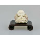 Netsuke, Japan, wohl 19. Jh., kleiner, sitzender Buddha, Elfenbein, am Boden signiert, H.: ca. 3