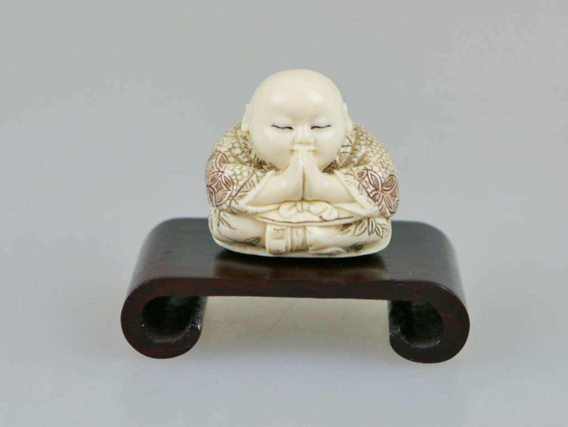 Netsuke, Japan, wohl 19. Jh., kleiner, sitzender Buddha, Elfenbein, am Boden signiert, H.: ca. 3