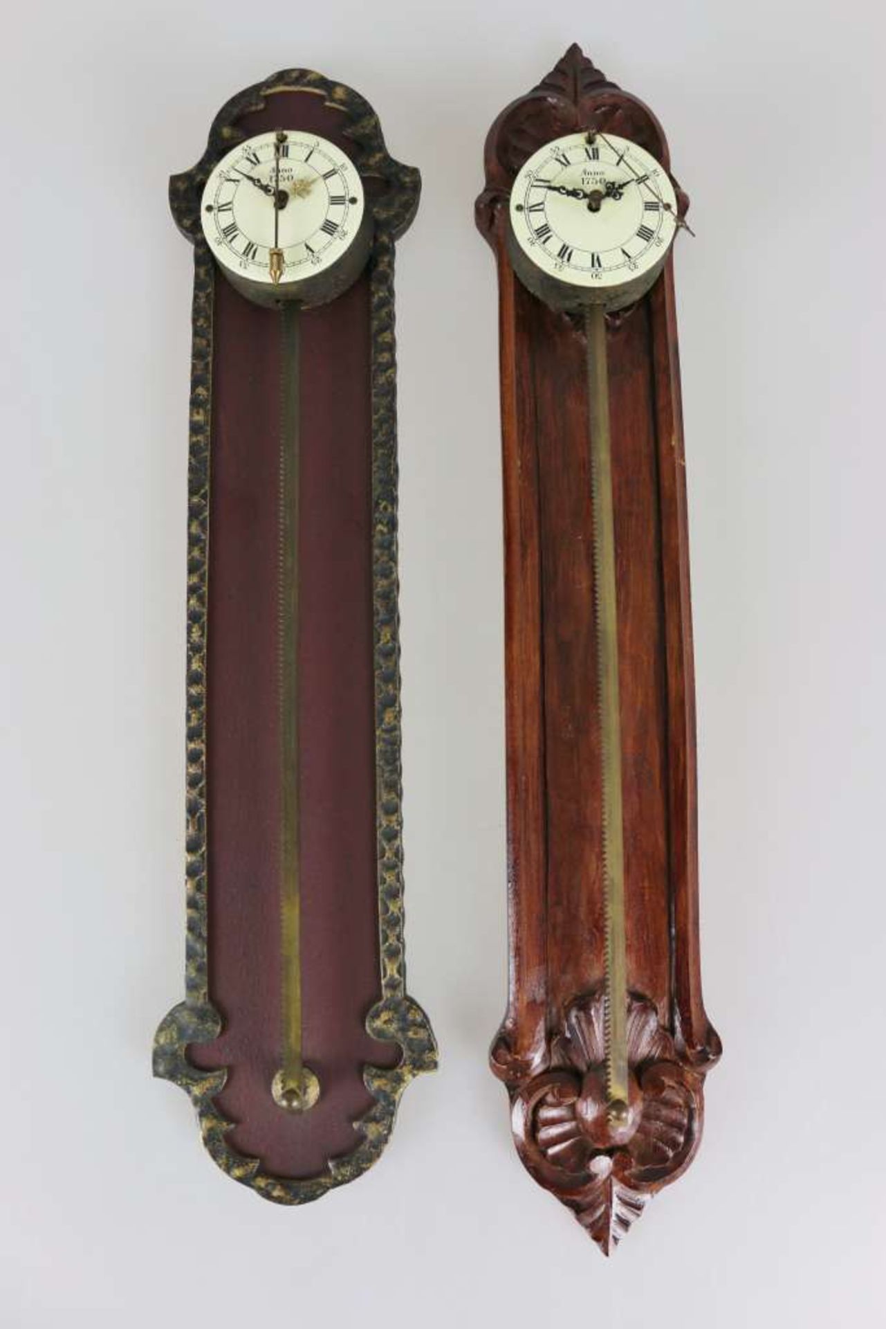 Paar Sägeuhren, 20. Jh., Holz und Eisen, rundes Werkgehäuse, cremeweißes Zifferblatt mit römischen