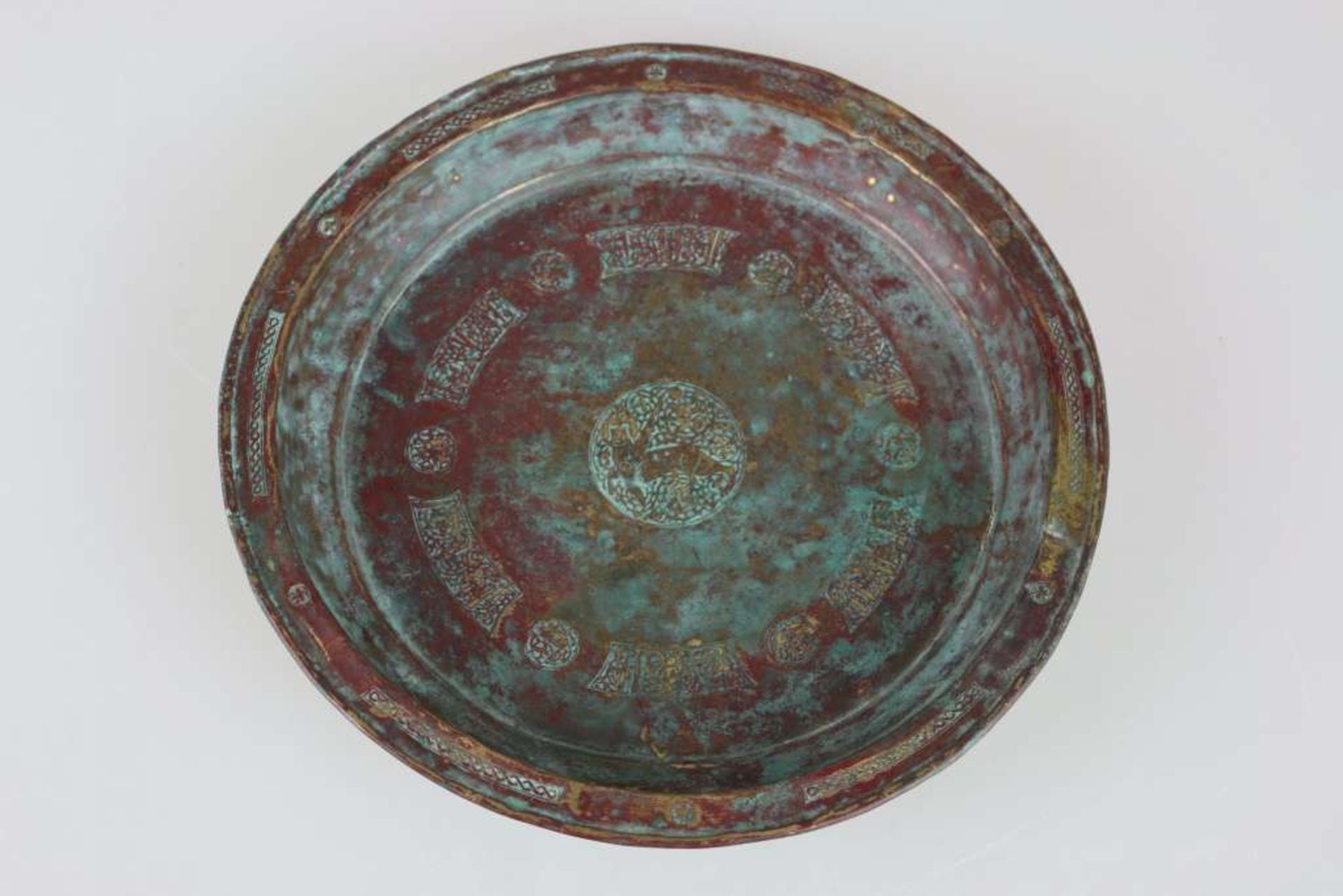 Persien um 1400, tiefgemuldeter Teller aus Messing, im Spiegel reichhaltig verziert, mit Darstellung