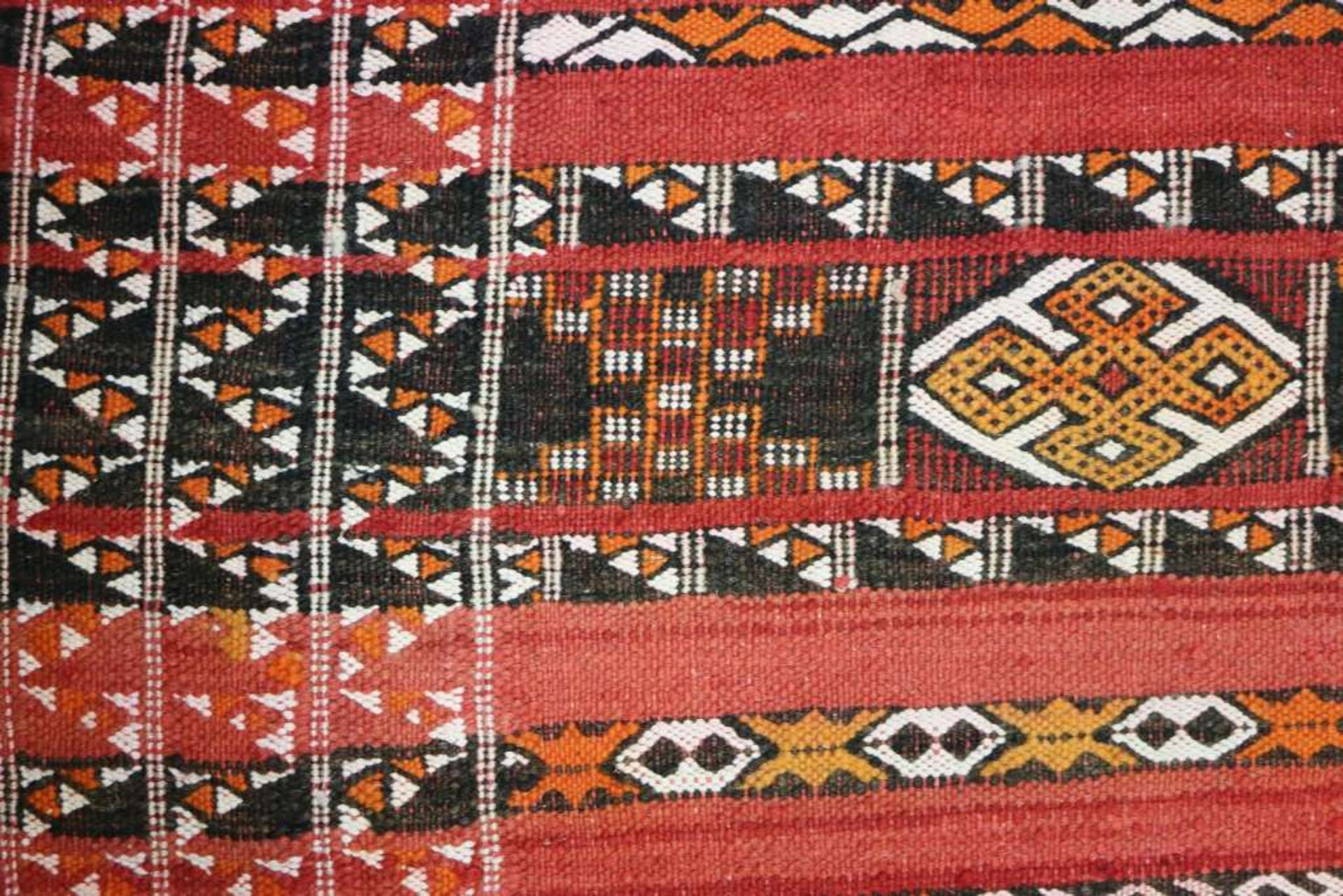 Marokkanischer Teppich, 1. H. 20. Jh., Flachgewebe, rotgrundig, alternierendes Streifendekor mit - Bild 2 aus 3