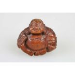 Okimono, Japan, wohl 19. Jh., sitzender Buddha Hotei, Holz, H.: ca. 5 cm.