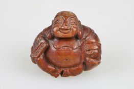 Okimono, Japan, wohl 19. Jh., sitzender Buddha Hotei, Holz, H.: ca. 5 cm.