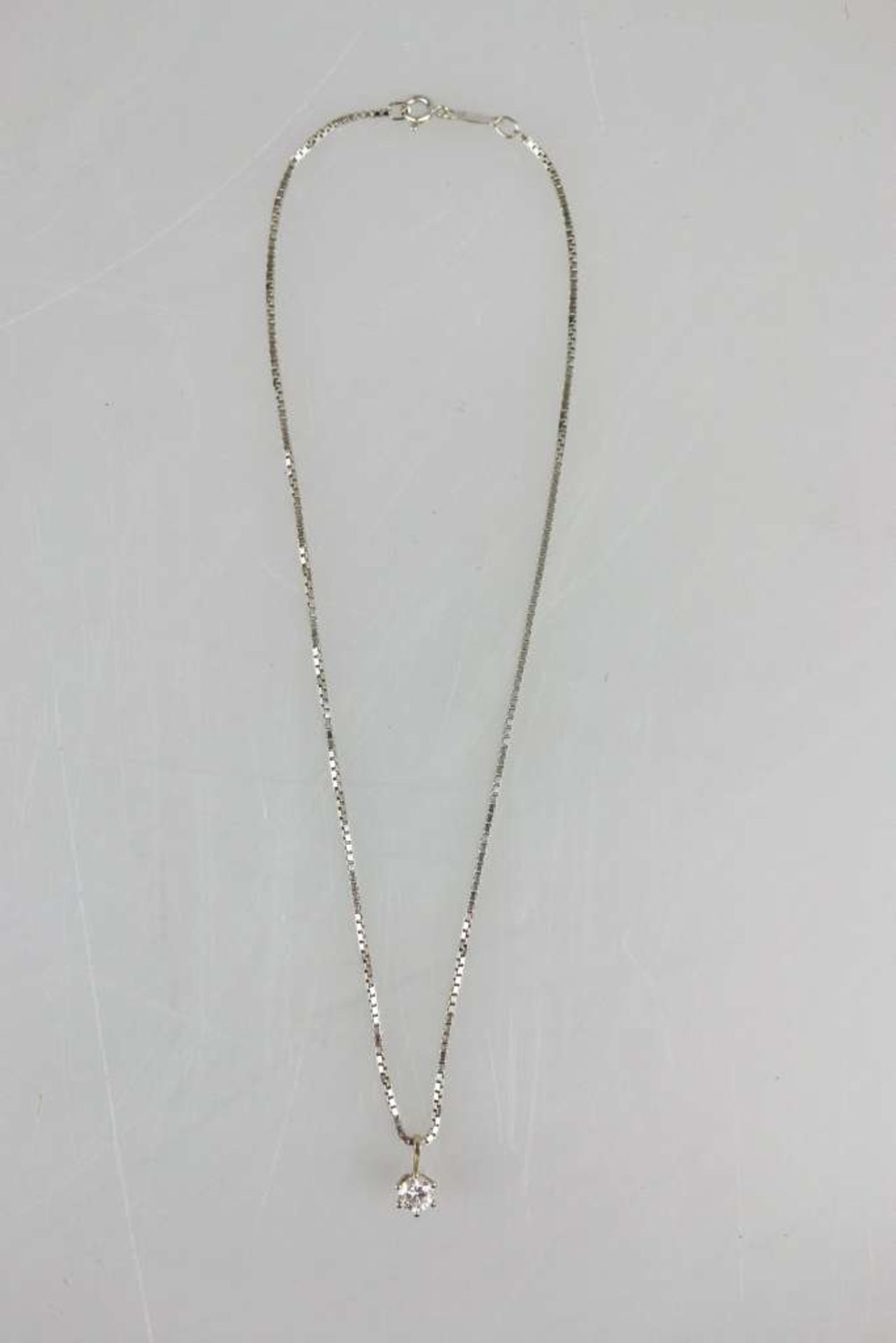 Halskette mit Solitär-Diamant, filigrane Kette in 750er WG, daran kronenförmige Fassung in 585er WG,