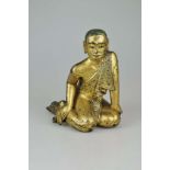 Ananda, Holzfigur mit Lackvergoldung und kleinen Glassteine, wohl Tibet 19./20. Jh., sitzende