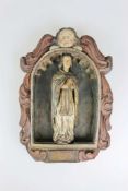 Heiligenfigur in einer Nische, wohl 17. Jh., Holz, gefasst, Segmentbogen mit Muschelstruktur,