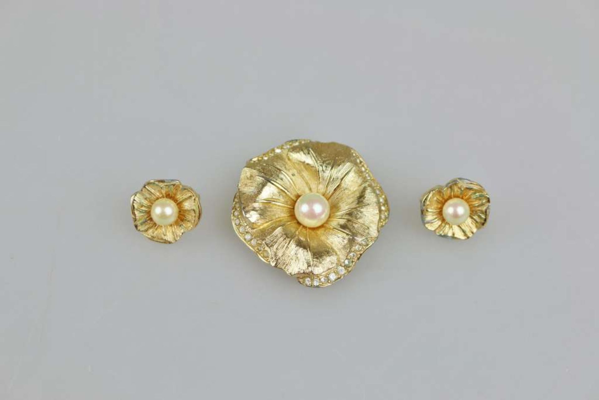 DIOR Modeschmuck, Brosche und Paar Ohrclips in Blütenform, jew. mit einer Perle besetzt, Metal