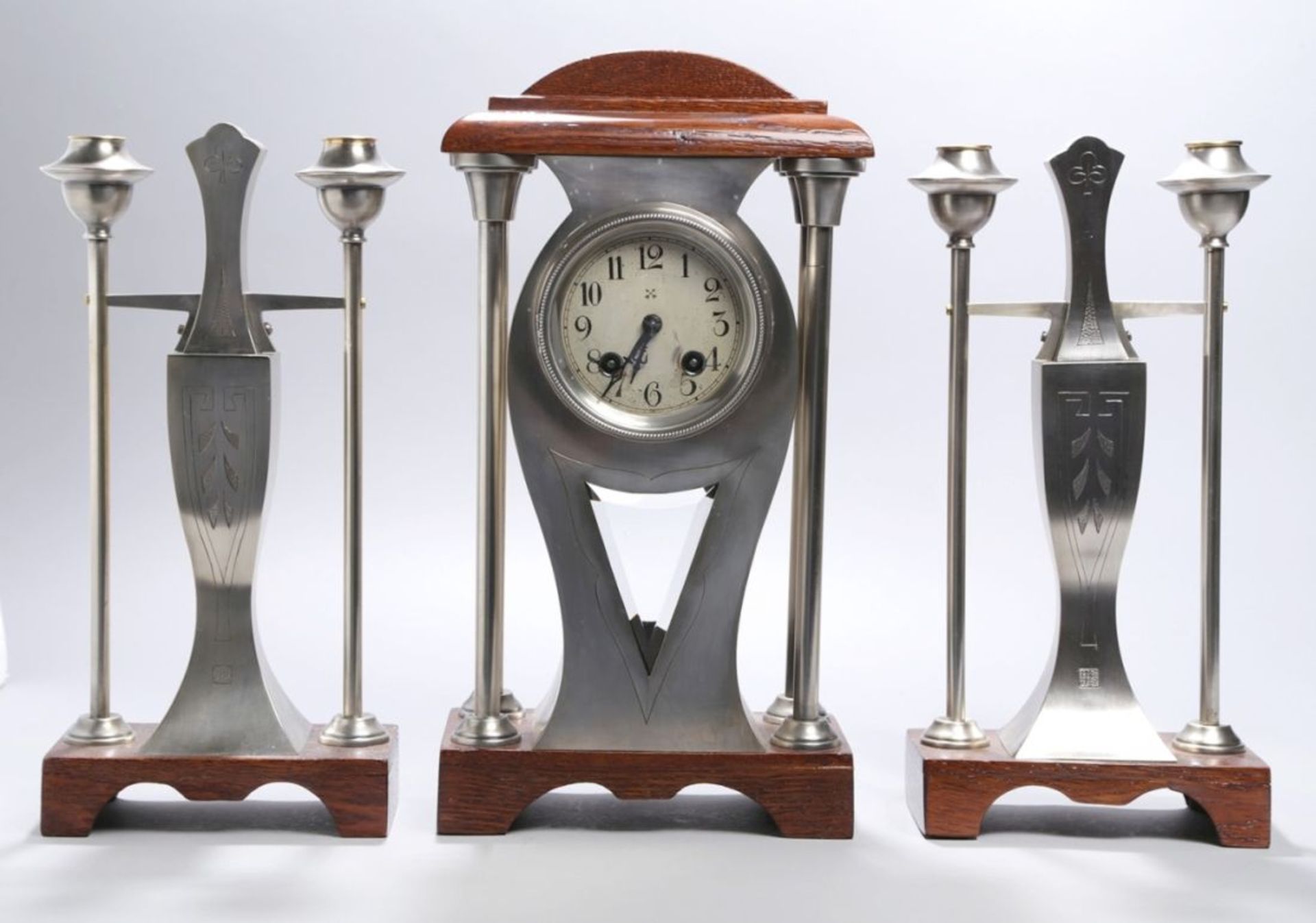 Uhren-Garnitur, 3-tlg., dt., um 1900/10, Metall poliert und mattiert, Holzsockel,