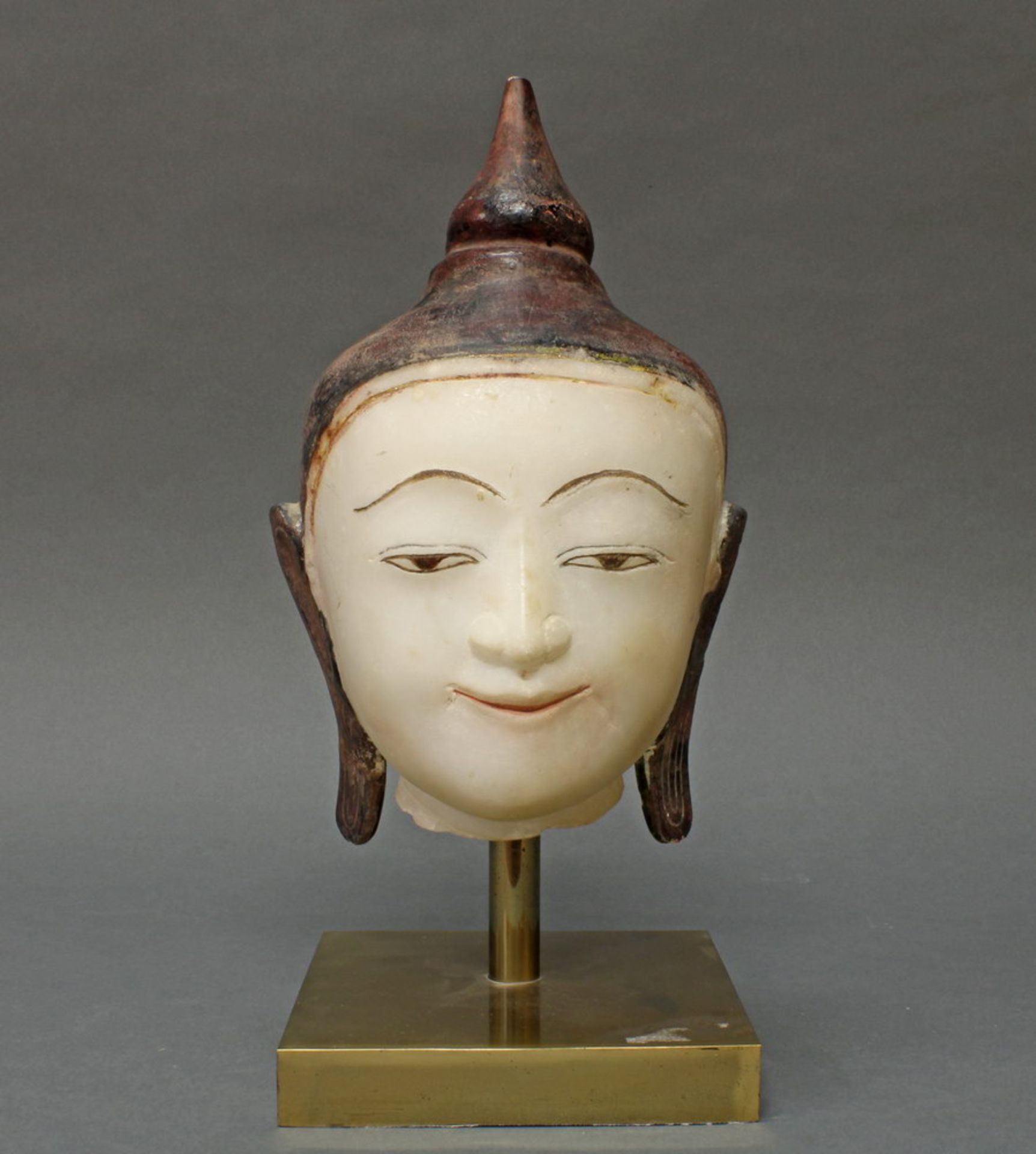 Buddhakopf, Burma, spätes 19. Jh., Alabaster, partiell farbig bemalt, auf späterem Messingsockel, 28