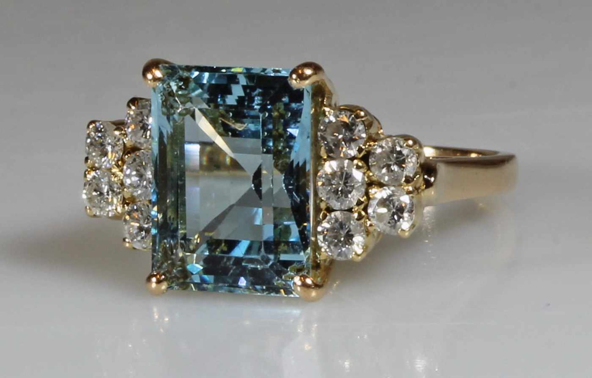 Ring, GG 750, 1 Aquamarin ca. 5.80 ct, Smaragdschliff, 10 Brillanten zus. ca. 0.65 ct., etwa w/p1,